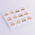 Macro shot of twelve pairs of gold metal cross stud earrings with colorful enamel filling - Enamel Cross Style (12 Pairs)
