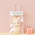 Creamy white coral fleece towel folded into a rabbit shape in a transparent gift bag - Beige + OPP Handbag