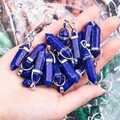 Donkerblauwe zeshoekige kristallen hanger met zilveren oogje getoond in de handpalm - Lapis lazuli