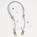 Detail of silver leather bag strap featuring gold metal tips and round spring buckles - Gold Ring Buckle / Bright Silver