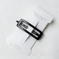 Polished black rectangular hair clip made of resin on a white display card - Rectangle / Solid Black