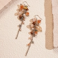Dettaglio di orecchini boho con perle di vetro e nappe in tonalità arancio e ambra - Perno per orecchini in argento - Caffè