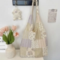 Detail of floral patchwork shoulder bag with woven label and textured hobo design - Purple Plaid