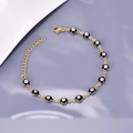 Dettaglio del bracciale Evil Eye dorato con ciondoli in smalto nero e chiusura a moschettone - Nero