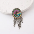 Close-up of rainbow woven letter G brooch featuring sparkling rhinestone fringe detail - Letter G