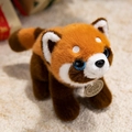 Adorable red panda plush toy with white face and blue sequin eyes on soft rug - Red Panda