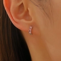 Close-up of silver hoop earring with three inlaid pink zircon stones on model's ear - White Gold Style (A-556)