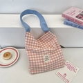 Sac cabas en toile à carreaux rose et blanc avec bandoulière bleue dans un décor lifestyle - Rose Chair