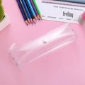 Nahaufnahme der durchsichtigen PVC-Federtasche mit silbernem Druckknopf auf Rosa - Transparent