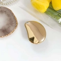 Elegante depiladora de cristal en forma de guijarro con acabado espejo dorado sobre mármol - Lágrima / Dorado