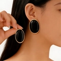 Vintage oval resin stud earrings with black glaze and golden frame on female model - Oval Style (X661) / Black