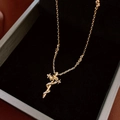 Close-up of gold cross sword necklace with cubic zirconia on black velvet box - Gold