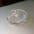 Macro-opname van zilveren crossover armband met dichte pavé diamantzetting en geometrisch design - 7# Zilveren opengewerkte armband