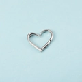 Orecchini a cerchio a cuore in argento lucido su uno sfondo azzurro minimalista - Ciondolo a Cuore Singolo Colore Acciaio