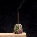 Incense holder made of colorful crystal agate stone with burning incense on wood base - Dragon Blood Stone