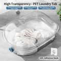 Diepe ovale transparante PET-wastobbe met witgoed in een sopje van zeepwater - Transparante wastobbe / Met haak