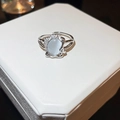 Detailed macro shot of silver geometric ring with oval opal stone and crystal accents - Oval Gemstone Inlaid Style