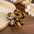 Elegant tortoise shell flower hair claw clip in amber brown finish on a wooden surface - 7cm / Camouflage Dark Tortoiseshell