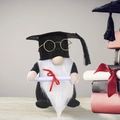 Graduation gnome plush toy wearing black cap and glasses with diploma on wooden desk - Beard Style