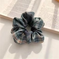 Blue and green plaid fabric scrunchie on a vintage book with soft natural lighting - JK Forest Letter
