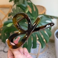 Close-up of deep amber tortoiseshell resin hair claw clip with durable metal spring - Glossy Light Tortoise