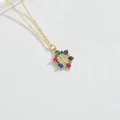 Macro shot of gold necklace pendant with Virgin Mary relief and multi-color zircon stones - Floral Design Virgin Mary