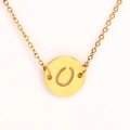 Détail d'un collier doré avec pendentif rond présentant une lettre O gravée et ajourée - Lettre O