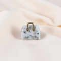Mini handbag pendant made of white natural stone with black spots and gold handle - Tianshan Blue