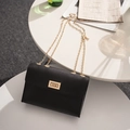 Classic black leather chain crossbody bag with an elegant golden rectangular twist lock - Black