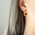 French style gold U-shaped earrings with brown tiger eye stone spheres on model - Gold Tiger Eye Earrings