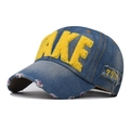 Détail macro de casquette de baseball en denim bleu avec broderie FAKE jaune pelucheuse - Réglable / Jaune