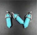 Macro detail of turquoise hexagonal prism pendants with silver metal caps on grey surface - Blue Turquoise
