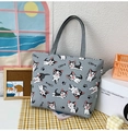 Detail of grey canvas tote bag featuring a cartoon cat print on a checkered tablecloth - Cat