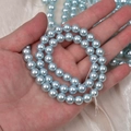 Hand holding high-gloss light blue faux glass pearl beads for DIY jewelry making - 4mm Straight Hole/Approx 100pcs Per Strand / Lake Blue