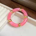Pink marble acrylic bamboo tube bracelet with golden metal spacers on jewelry display - Pink