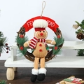 Details des Lebkuchenmann-Weihnachtskranzes mit Feliz Navidad Banner und Beeren - Lebkuchenmann mit Kochmütze Kranz