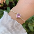 Elegante bracciale a cuore placcato oro 18 carati con zircone rosa al polso di una modella - Rosa
