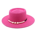 Dettaglio di un cappello di paglia rosa con trama fine ed elegante bordo di perle - Rosa Rosso