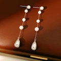 Dettaglio di eleganti orecchini di perle con catena d'argento su scatola in pelle - Orecchini Lunghi di Perle con Perno in Argento S925 / Argento-Rosa-Bianco