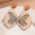 Détail de boucles d'oreilles en bois goutte d'eau avec motif papillon dans un plat en céramique - Imprimé Ailes de Papillon (Couleur Bois Naturel)