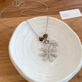 Details einer silbernen Halskette mit zwei Blumen, Hammerschlag-Optik und Tigerauge - Silber