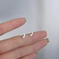 Polished 925 sterling silver hollow heart stud earrings held by hand to show size - Hollow Heart III / Silver