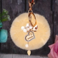 Détail du porte-clés pompon jaune avec cœur en bois et gravure I Love You - Cœur en bois + Pompon beige