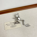 Detailed macro view of a polished silver frog brooch on minimalist fabric background - 44 Silver Frog (U-13)