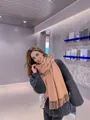 Classic camel pashmina scarf with tassels worn with a dark grey sweater on female model - Red Beige