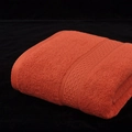 Absorbent orange cotton bath towel with textured terry loops and jacquard border detail - Crimson