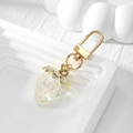 Macro view of a strawberry charm made of translucent resin with sparkling pearlescent effect - Transparent Strawberry Keychain