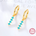 Detailed close-up of 925 sterling silver hoop earrings with blue turquoise pendants - Gold/Turquoise Blue