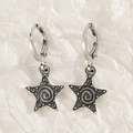 Orecchini a stella in argento vintage con trama a spirale su carta bianca stropicciata - Stella Argento Antico