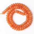 Detalle macro de cuentas naranjas en forma de ábaco para joyas DIY en piedra natural - Jade Teñido Naranja Ábaco